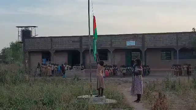 Extrait vidéo : le drapeau est descendu devant les élèves alignés.