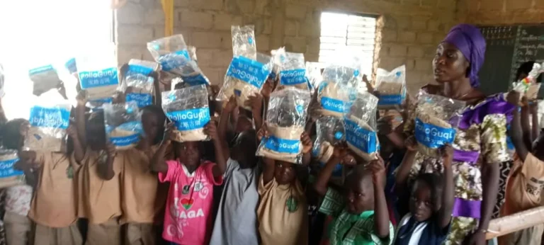 Gros plan sur des élèves brandissant leurs kits dans la classe.